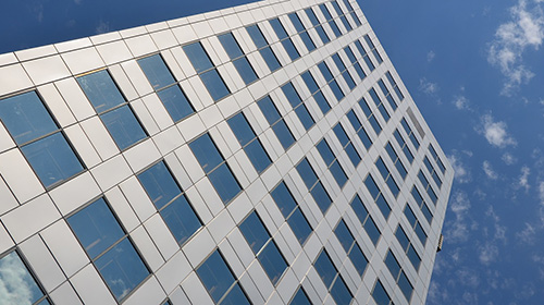 looking straight up the side of a tall office building at the sky