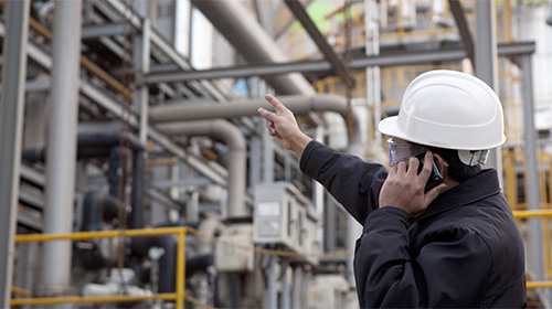 technician inspecting large industrial equipment for preventative maintenance